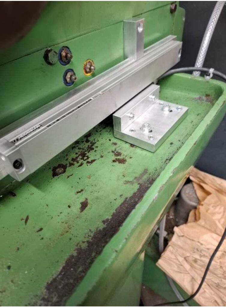 Scale fitted with adjustment grub screws in use to flatten the head bracket against the slurry tray.